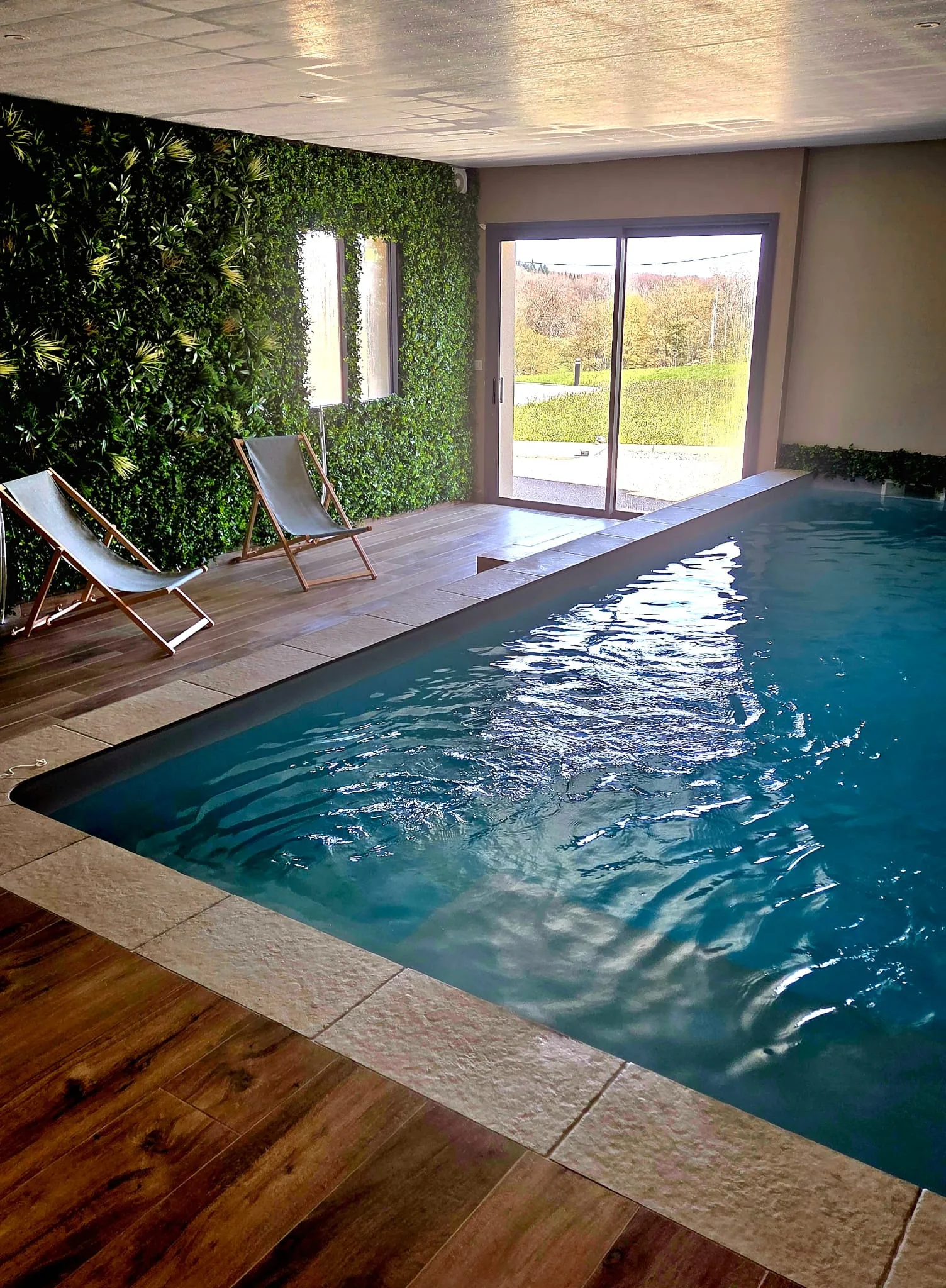 Piscine intérieure chauffée mur végétal